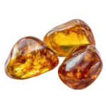 conjunto de tres cantos rodados de ámbar báltico pulido, de color amarillo dorado intenso a coñac, con inclusiones internas brillantes, aislados sobre un fondo blanco puro.